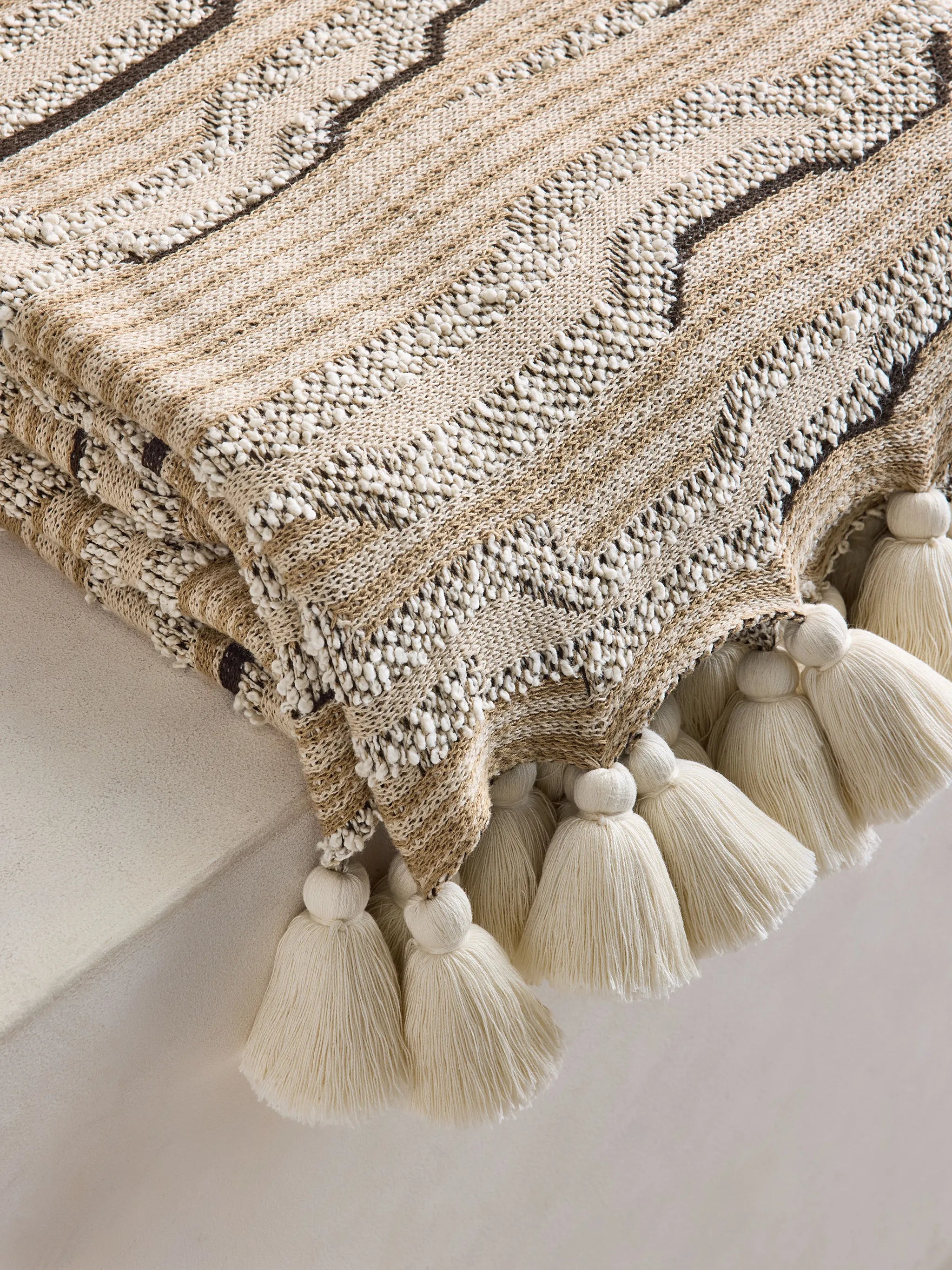 Cloud knitted tassel-detail throw